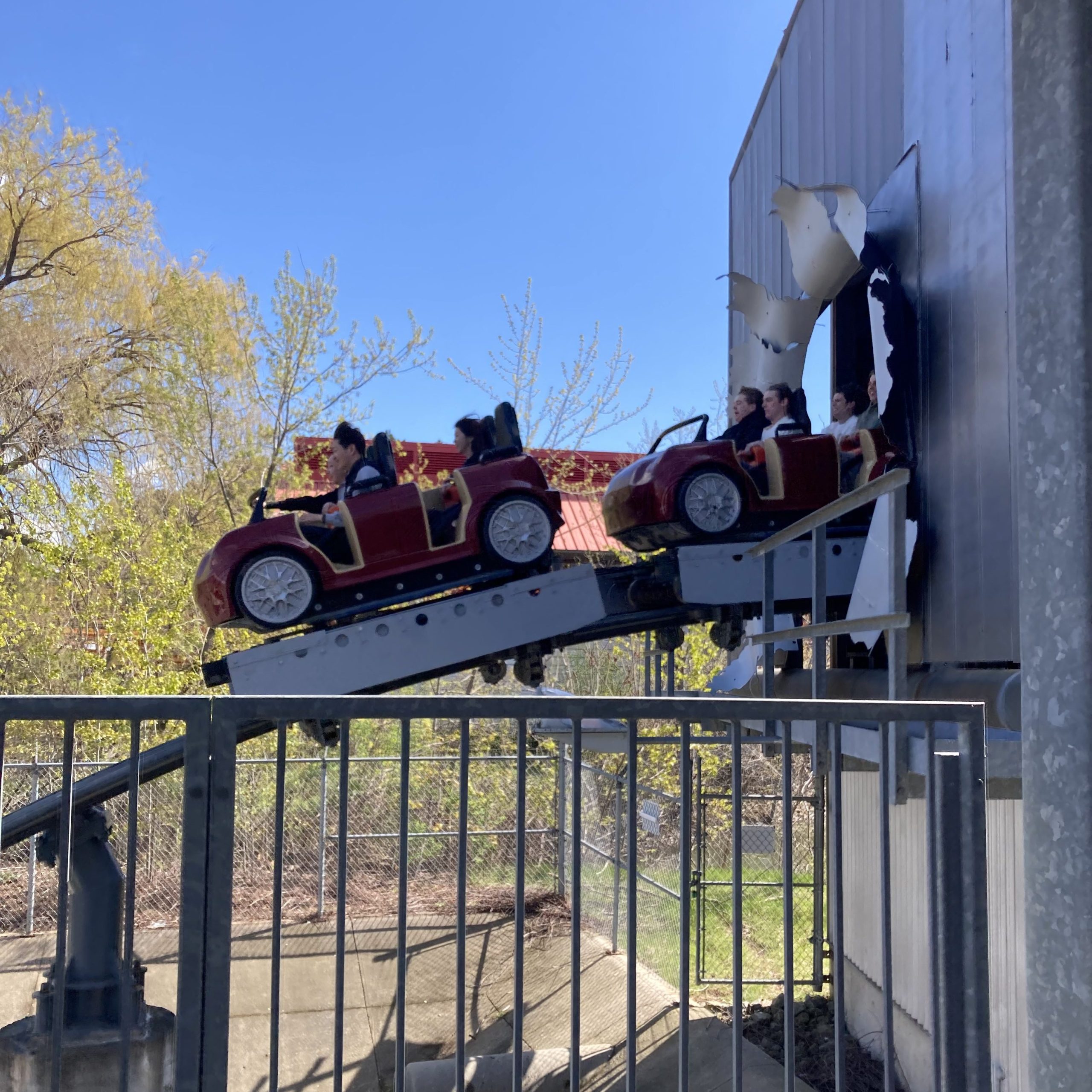 A train crashing through the fake billboard on Backlot Stunt Coaster.