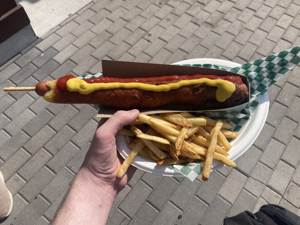 A foot long corn dog and fries.