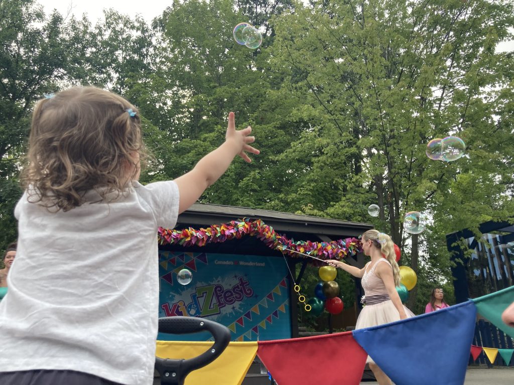 Emma trying to grab bubbles at The Fantastic Bubble Show.