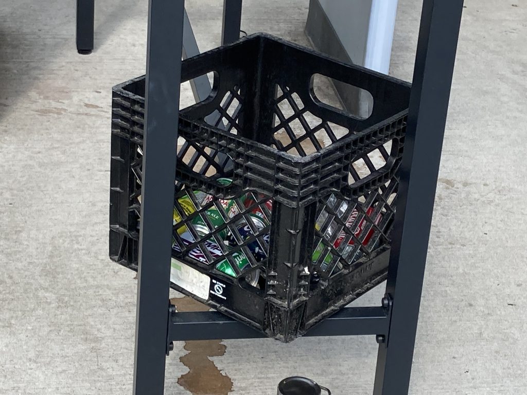 A milk crate filled with drinks.