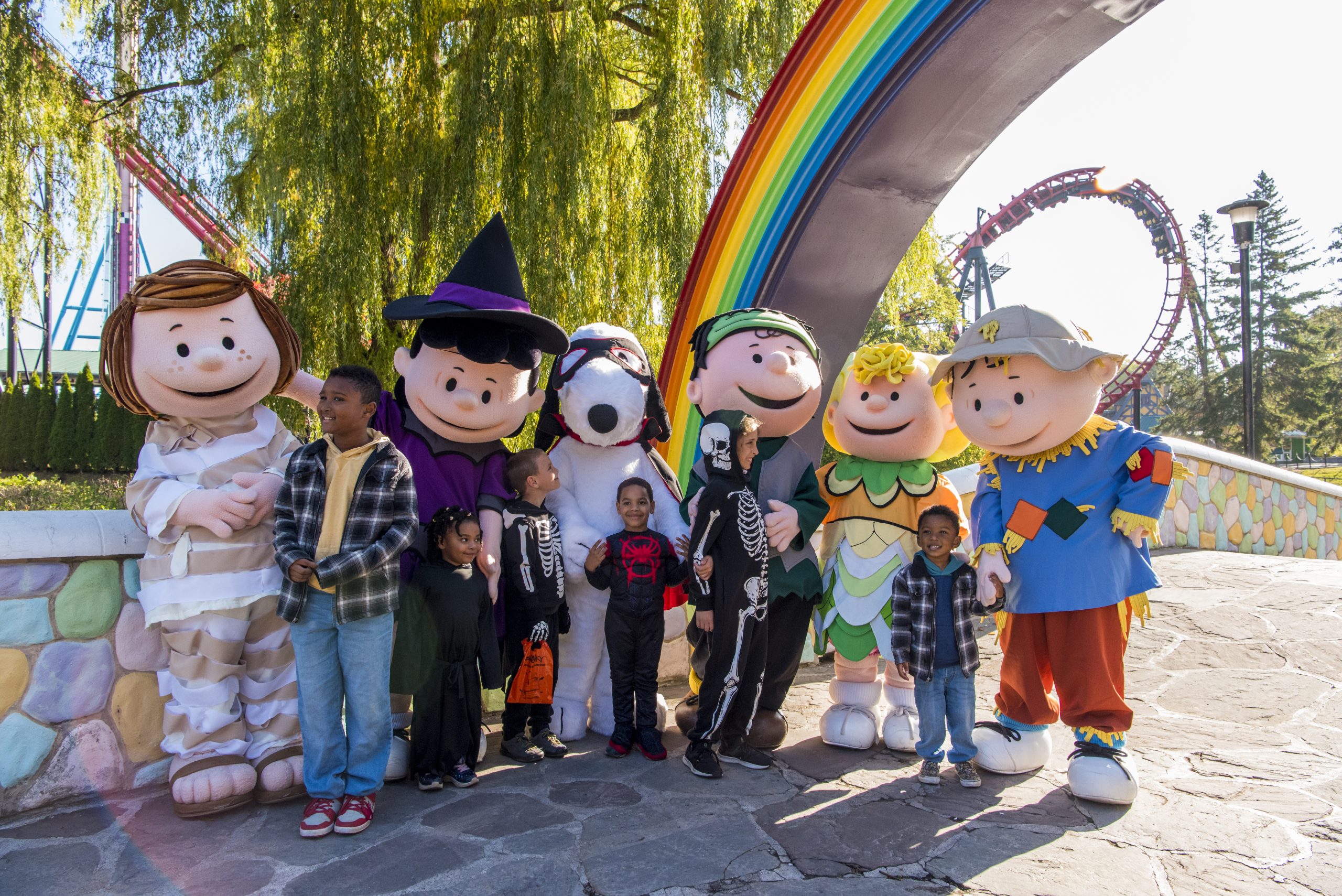 The Peanuts gang in their Halloween costumes, standing on the rainbow bridge.