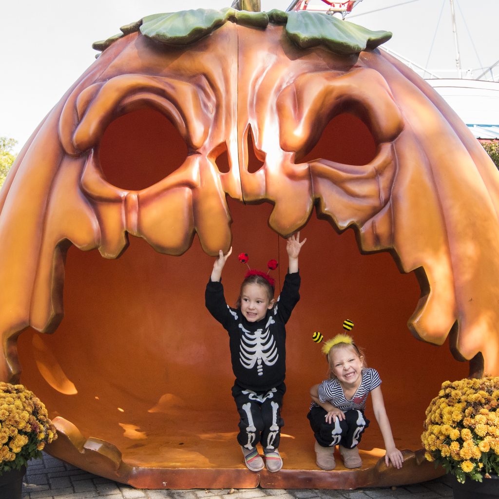 Kids standing in a giant jack-o-lantern.